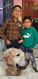 Two kids posing indoors with a Golden Retriever.