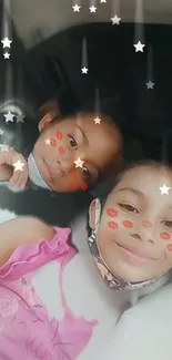 Two smiling kids with masks and starry effects on a playful wallpaper.