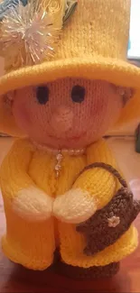 Charming knitted doll in bright yellow yarn with accessories.