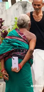 Elderly person holding phone in garden scene.