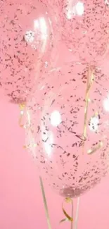 Pink wallpaper with clear balloons and gold confetti.