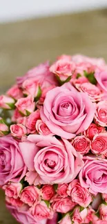 A bouquet of vibrant pink roses on a wooden background.