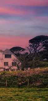 Charming cottage under a pink sunset sky with lush greenery.