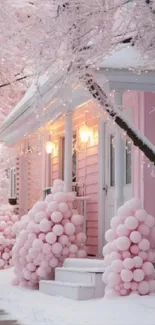 Pink winter cottage with balloons and snow-covered trees.