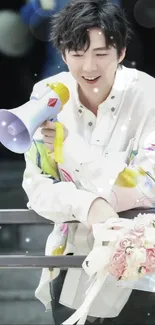 Person with megaphone and bouquet in vibrant shirt, smiling.