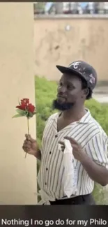 Man holds red rose in romantic wallpaper scene.