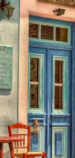 Rustic Mediterranean blue door with wooden chair outside a cafe.