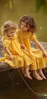 Children in yellow dresses on a dock by a serene pond.