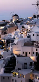 Santorini village illuminated at dusk against a lavender sky.