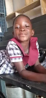 Charming child in school uniform smiling joyfully at the camera.