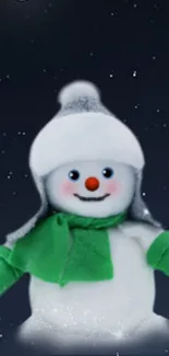 Snowman with green scarf under moonlit sky.