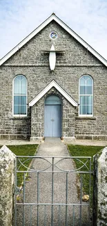 Charming stone church with blue doors and scenic surroundings.