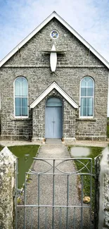 Mobile wallpaper of a stone church with arched windows and rustic surroundings.