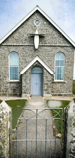 Front view of a charming stone church with Gothic architecture and a serene landscape.