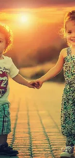 Two children holding hands at sunset with a warm, glowing sky.