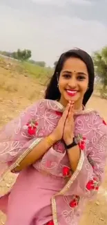 Woman in traditional attire with floral shawl in serene setting.