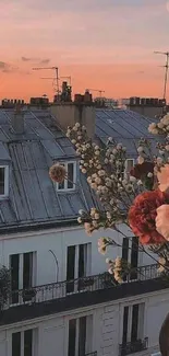 Urban sunset with flowers and rooftops.