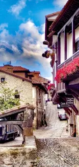 Charming village street with cobblestones, flowers, and historic buildings.