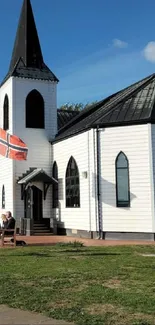 White church with blue sky and pathway in a serene setting.