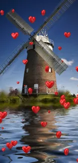 Windmill with red hearts reflecting in a calm lake, blue sky background.