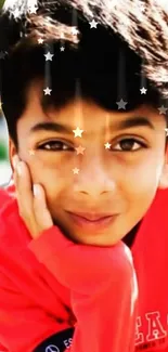 Boy in a red shirt with stars overlay, smiling vividly.