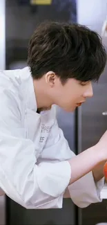 Chef in white uniform focusing on food in professional kitchen.