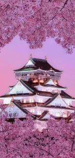 Japanese castle framed by cherry blossoms under a pink sky.