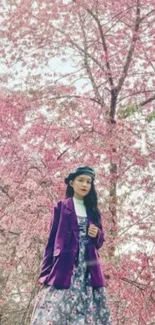 Stylish woman in floral attire with pink cherry blossoms in the background.