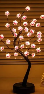 Illuminated cherry blossom lamp on table.