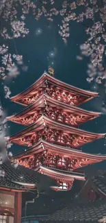 Japanese pagoda surrounded by cherry blossoms at night.