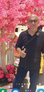 Man posing with cherry blossoms and decor outdoors.