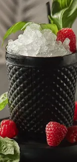 Stylish black cocktail glass with ice and raspberries.