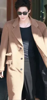 Person wearing brown coat and sunglasses, stylish fashion.