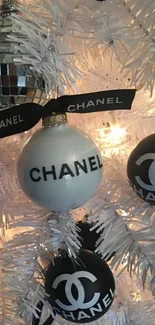 Chanel Christmas ornaments on a white festive tree with elegant design.