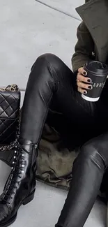 Stylish woman in black leather, holding coffee.