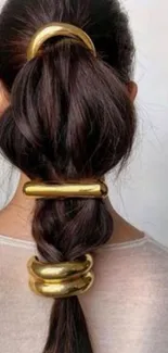 Braided ponytail with gold accessories.