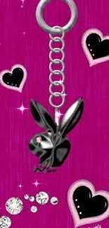 Black bunny keychain on pink heart background wallpaper.