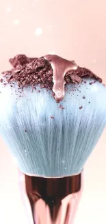 A pastel blue makeup brush with shimmering powder accents.