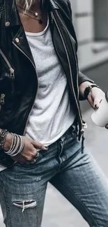 Woman in leather jacket with coffee on street.