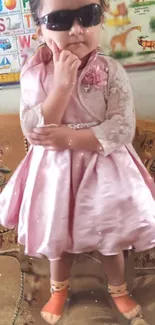 Toddler wearing pink dress and sunglasses