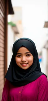 Stylish young woman in magenta hijab in urban setting.