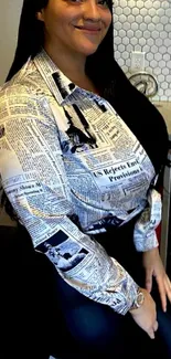 Elegant woman in a newsprint shirt, seating on a bar stool.