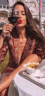 Stylish woman enjoying wine at an outdoor cafe.