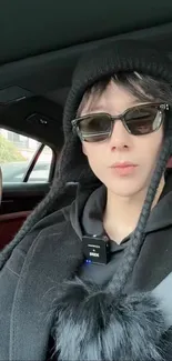 Chic winter fashion look with sunglasses, black attire in car.