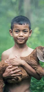 Boy holding goat in green forest background.