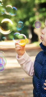 Young child blowing bubbles in a sunlit park.