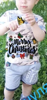 Child holding a butterfly with a Christmas-themed shirt.