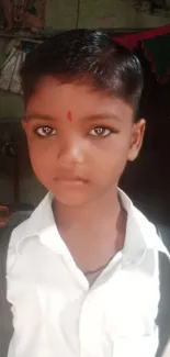 Young boy in a school uniform with earthy background tones.