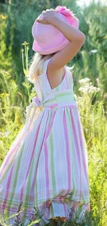 Child in pastel dress standing in a sunny meadow.