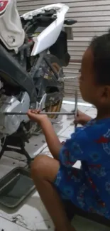 Child in Spiderman outfit working on motorcycle.